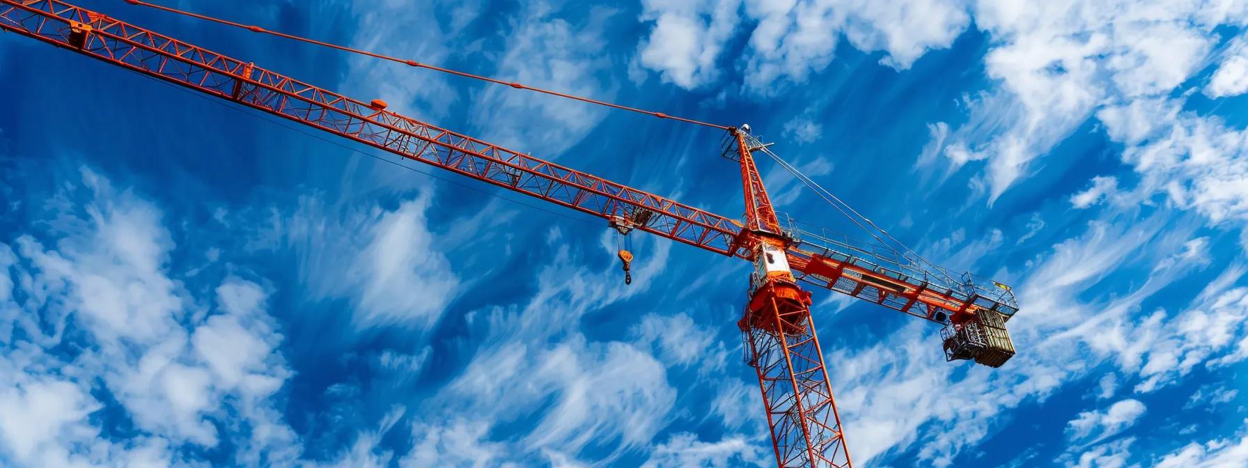 Orange construction crane against a blue sky with clouds, symbolizing commercial crane services in Boston and Massachusetts.