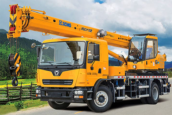 Heavy-duty boom crane on a truck, set against a scenic backdrop, representing MacDonald Crane's professional crane rental services in Brockton, MA, for construction and HVAC projects.