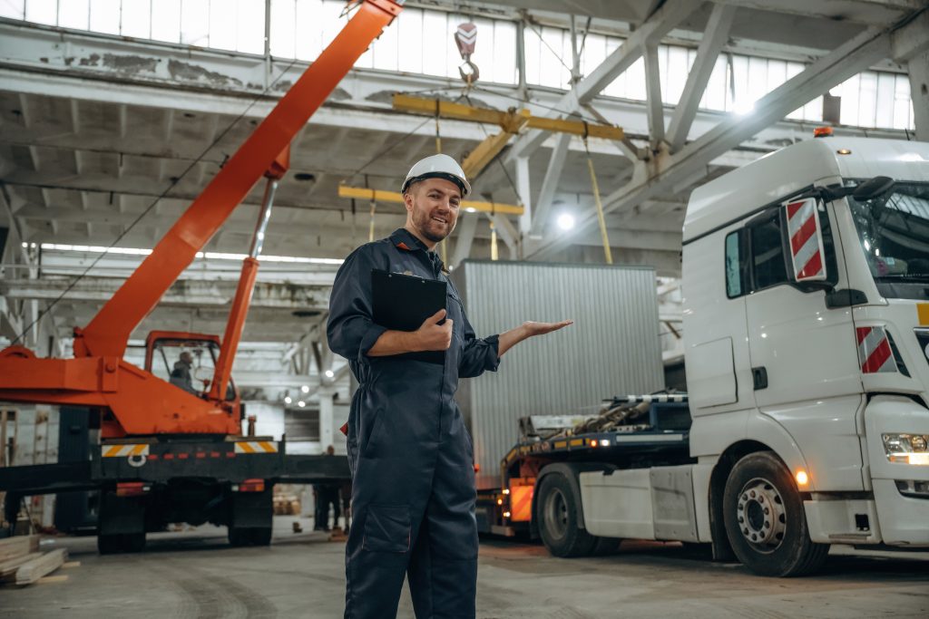 Male crane operator in a warehouse, showcasing crane operations and heavy lifting equipment, emphasizing safety and precision in lifting services.